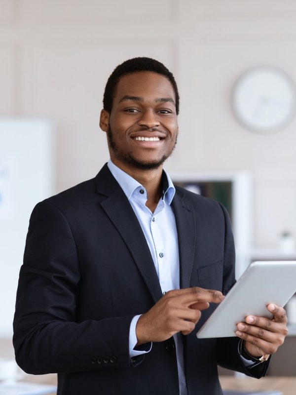 smiling-black-entrepreneur-holding-digital-tablet-office-interior.jpg
